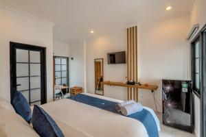 a bedroom with a bed and a tv in it at Little Soho Pererenan in Canggu