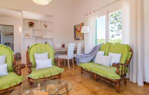 a living room with green chairs and a table at Sa Caseta De Portocolom in Felanitx