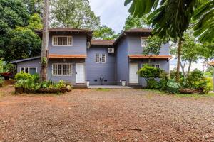 a blue house with a tree in front of it at Beer Hotel Iguazú in Puerto Iguazú