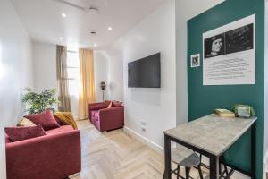 a living room with two red chairs and a table at The Pocklington Aparthotel - Luxury 1 & 2 Bed Serviced Apartments, City Centre, Perfect For Families, Contractors and Businesses in Leicester