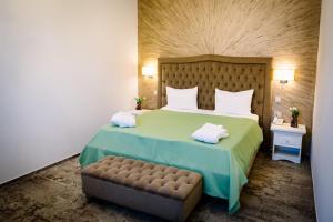 a bedroom with a large bed and a bench at Hotel-Restaurant La Belle Epoque in Petroşani