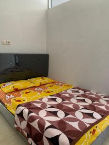 a bedroom with a bed with a comforter on it at Herald homestay wonosobo in Wonosobo +2 photos