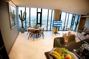 a kitchen and living room with a table and chairs at Volcano View Loft, Puebla Skyline1801 in Puebla