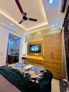 a bedroom with a bed and a flat screen tv at Urban Luxury Studio Apartment in Greater Noida