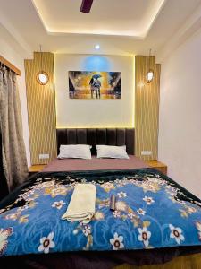 a bedroom with a large bed with a blue blanket at Urban Luxury Studio Apartment in Greater Noida +3 photos