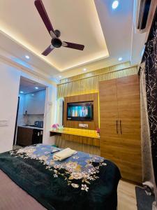 a bedroom with a bed and a ceiling fan at Urban Luxury Studio Apartment in Greater Noida