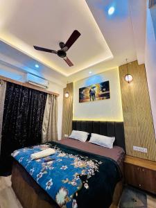 a bedroom with a bed with a ceiling fan at Urban Luxury Studio Apartment in Greater Noida