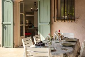 a dining room table with white chairs and a table with grapes on it at Villa Marie in Vence