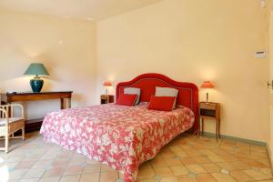 a bedroom with a large red bed with red pillows at Villa Marie in Vence