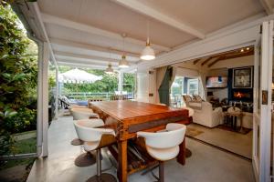 a dining room with a wooden table and chairs at Long Story Guest House in Plettenberg Bay