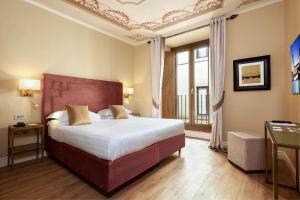 a hotel room with a large bed and a window at Grand Hotel Cavour in Florence +87 photos