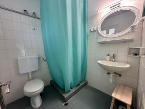 a bathroom with a blue shower curtain and a sink at Achladies Cottages in Achladies