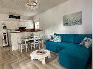 a living room with a blue couch and a table at Achladies Cottages in Achladies