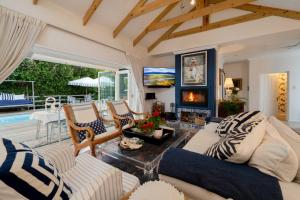 a living room with a couch and chairs and a fireplace at Long Story Guest House in Plettenberg Bay