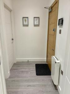 a hallway with a door and a room with a rug at 6 Aviv Place in Addlestone
