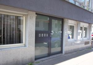 a glass door of a building with a car in it at City Apartment in Cologne