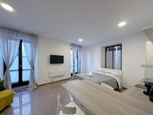 a white room with a bed and a tv at BBkey Corte San Daniele in San Daniele del Friuli