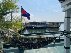 a hammock on a dock with a boat in the water at AHHA Floatel Kampot in Kampot +9 photos