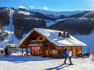 two people standing in the snow in front of a ski lodge at B&B Residenza San Giorgio in LʼAquila