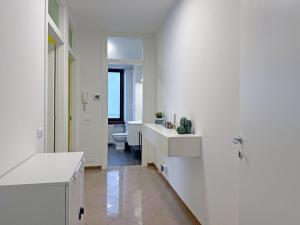 a white bathroom with two sinks and a toilet at BBkey Corte San Daniele in San Daniele del Friuli +28 photos