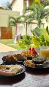 a table topped with plates of food and drinks at Pousada Linhares in Canoa Quebrada