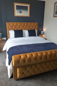 a bedroom with a large bed with a brown tufted headboard at Oliver Wests Beautiful 1 Bedroom Retreat in Scarborough