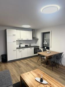 a living room with a table and a kitchen at Ferienwohnung am Wildpark Eichert HDH in Heidenheim an der Brenz