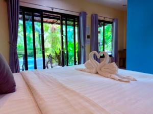 two swans sitting on top of a bed at Farinda Resort in Phangnga