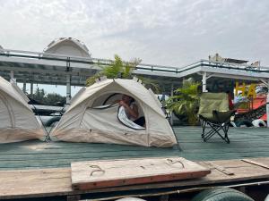 a person sleeping in a tent on a deck at AHHA Floatel Kampot in Kampot