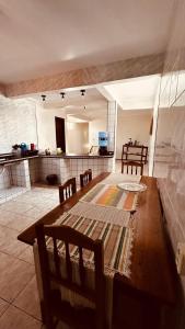 a kitchen with a long wooden table and chairs at Rochas - Suíte no Centro de Viçosa do Ceará in Viçosa do Ceará