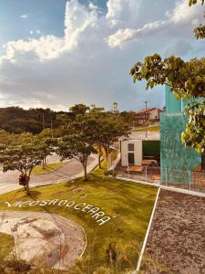 a park in front of a building with a sign at Rochas - Suíte no Centro de Viçosa do Ceará in Viçosa do Ceará