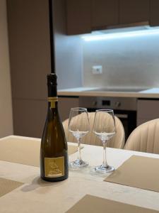 a bottle of wine and two wine glasses on a table at Olive Tree in Tirana +8 photos