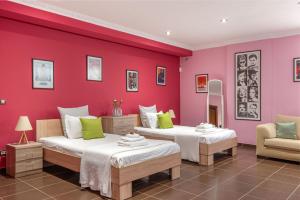 two beds in a room with a red wall at Villa Omega Kefalonia in Karavádhos +63 photos