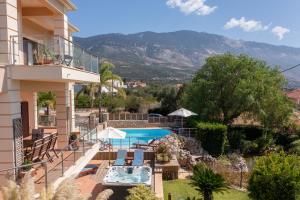 a villa with a swimming pool and mountains in the background at Villa Omega Kefalonia in Karavádhos