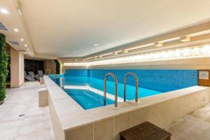 a swimming pool in a building with blue walls at Hotel Mursalitsa by HMG - Half board in Pamporovo