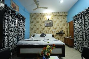 a bedroom with a bed and a table with flowers on it at Hotel Anand LOK in Rājgīr +49 photos