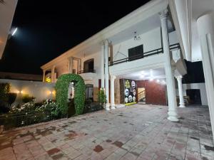 a large white building with columns and a courtyard at Hotel DE Smart Multan in Multan