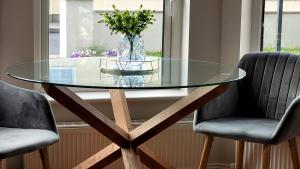 a glass table with two chairs and a vase with flowers at Willow Lodge in Westport