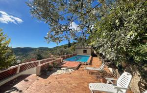 a house with a swimming pool and two white chairs at La Nature in Seillans