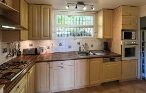 a kitchen with white cabinets and a sink and a window at La Nature in Seillans