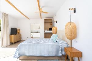 a bedroom with a bed with a blue and white blanket at Eden Rentals Costa Boho 2 in Las Galletas
