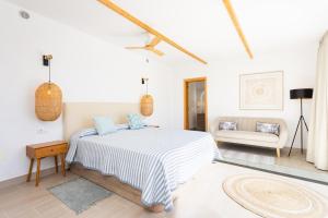 a white bedroom with a bed and a couch at Eden Rentals Costa Boho 2 in Las Galletas +69 photos