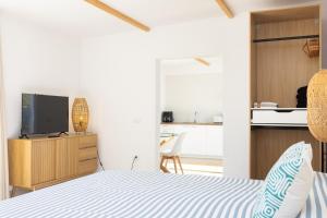 a bedroom with a bed and a tv on a cabinet at Eden Rentals Costa Boho 2 in Las Galletas