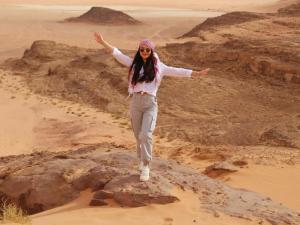 a woman standing on a rock in the desert at Wadi rum fun time in Wadi Rum