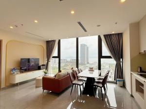 a living room with a couch and a table and chairs at Căn Hộ Cao Cấp - Villa 5 Phòng Ngủ Hạ Long in Ha Long