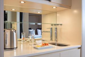 a kitchen counter with a sink and a mirror at Fraser Suites Edinburgh in Edinburgh +42 photos