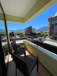 two chairs and a table on a balcony with a view at Hotel del Volcán in Pucón