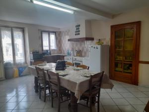 a kitchen with a table with chairs and a refrigerator at Voiron grande maison in Voiron