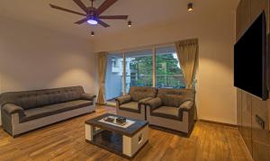 a living room with two couches and a flat screen tv at Treebo Atithi Comforts Inn in Pune