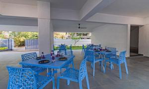 a dining room with blue tables and blue chairs at Treebo Atithi Comforts Inn in Pune
